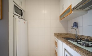 A kitchen with a microwave, refrigerator, sink, and stove. - Apts in a Building 100 Meters From Ufsc - Eoss (Florianópolis)