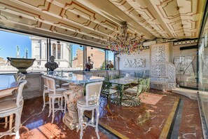 A luxurious interior with marble flooring, ornate furniture, and classical statues.