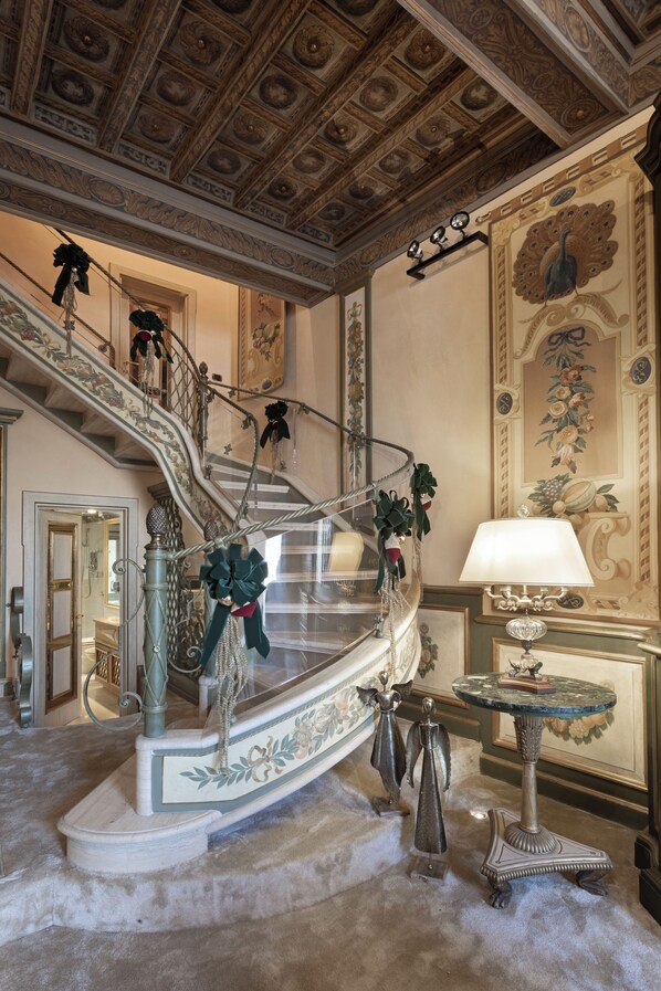 A grand staircase with ornate railings and a decorative lamp.