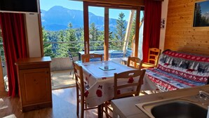 A cozy room with a dining table, chairs, a sofa, and a view of mountains. - V du Bachat Epicea B Ndeg22 - 3P6 (Chamrousse)