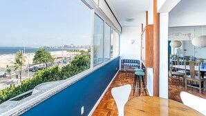 Un espace de restauration moderne offrant une vue sur la plage et le paysage urbain.