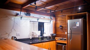 Una cocina con armarios de madera, un refrigerador de acero inoxidable, una estufa a gas y un salpicadero de mármol.