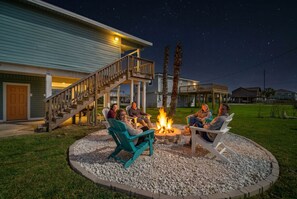Una casa con terraza, mobiliario exterior y una chimenea.