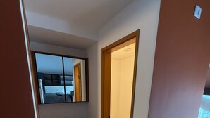 A modern bathroom with a large mirror, a sink, and a toilet. - Heritage X (São Paulo)