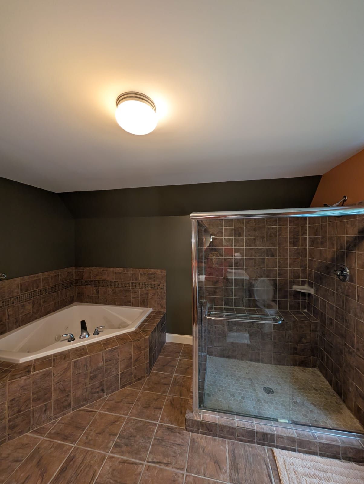 A bathroom with a freestanding bathtub and a glass-enclosed shower area.