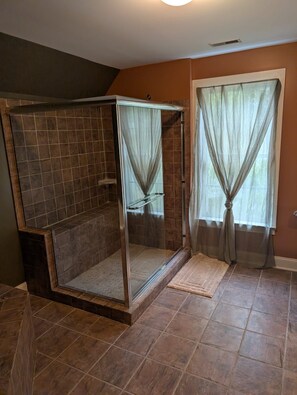 A bathroom with a walk-in shower, tiled walls, and a window with curtains. - Renewal Room at the Hilltop Hideaway King Bed (Hampstead)