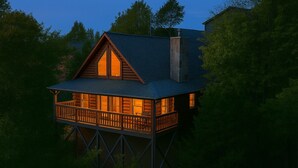 Eine Holzhütte mit Balkon, umgeben von Bäumen.