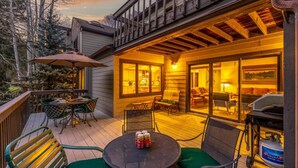 Eine Terrasse mit Gartenmöbeln, einem Grill und einem Essbereich mit Tisch und Stühlen.
