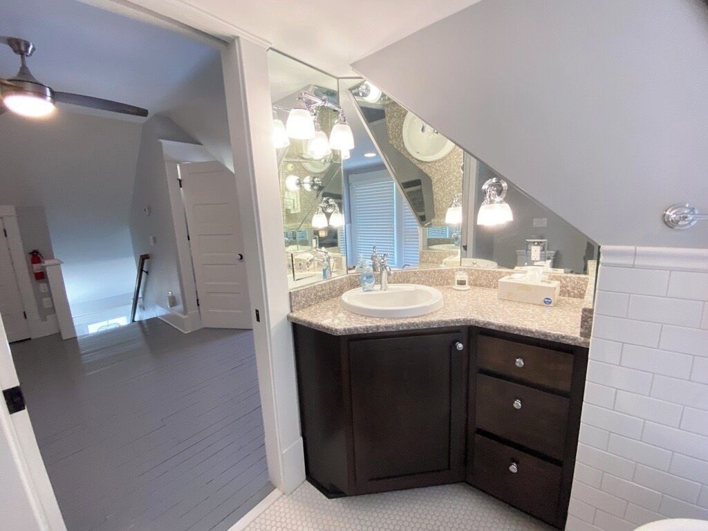 A modern bathroom with a vanity, sink, and mirror.