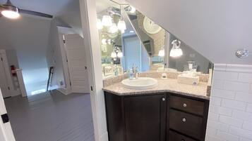 A modern bathroom with a vanity, sink, and mirror.