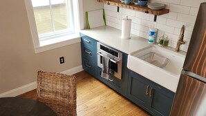 A modern kitchen with wooden flooring, a dining table, and a refrigerator. - 2nd Street Loft - Riverview (Washington)