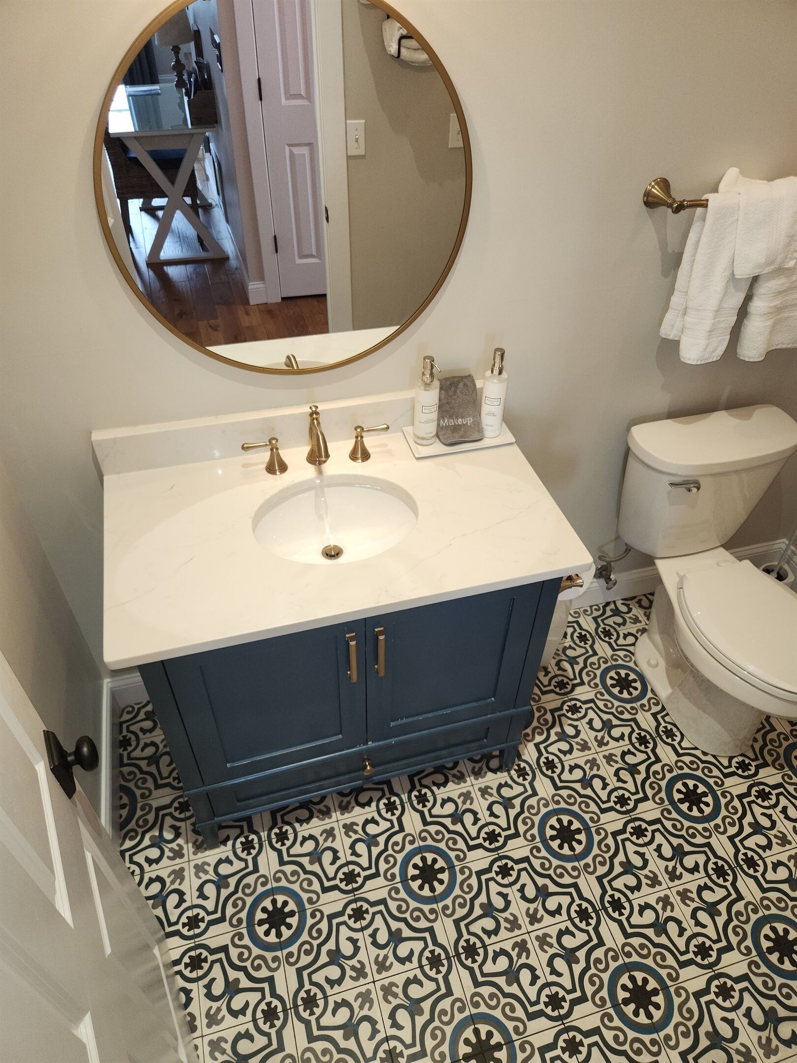 Un baño con lavamanos blanco, tocador azul y un inodoro.