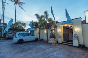 A residential property with a car parked in the driveway, a gated entrance, and a clear sky. - Semaya One Beach Hotel (Bali)