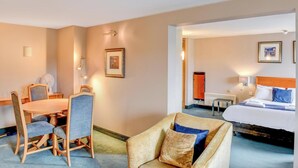 Une chambre d’hôtel avec un lit, un bureau, une chaise et un canapé.