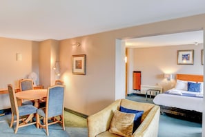 Una habitación de hotel con cama, escritorio, silla y sofá.