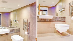 Une salle de bain moderne avec deux lavabos, une douche et des toilettes.