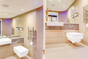 Une salle de bain moderne avec deux lavabos, une douche et des toilettes.