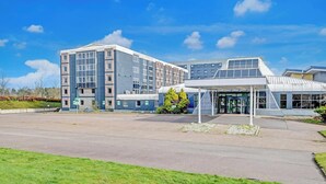 Un bâtiment moderne doté d’une entrée abritée, de grandes fenêtres et d’un toit plat.