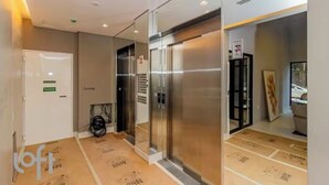 Un ascenseur doté d’un panneau de commande et d’une porte. Le sol est recouvert d’un matériau de protection.