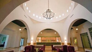 A spacious lobby with a high ceiling, arched architecture, and a central chandelier. - Ecrin Club  (Hammamet)