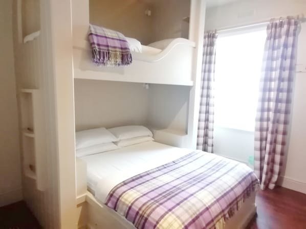 A bunk bed with a purple and white checkered blanket, white pillows, and a white headboard. - The Rocks at Plas Curig (Betws-Y-Coed)