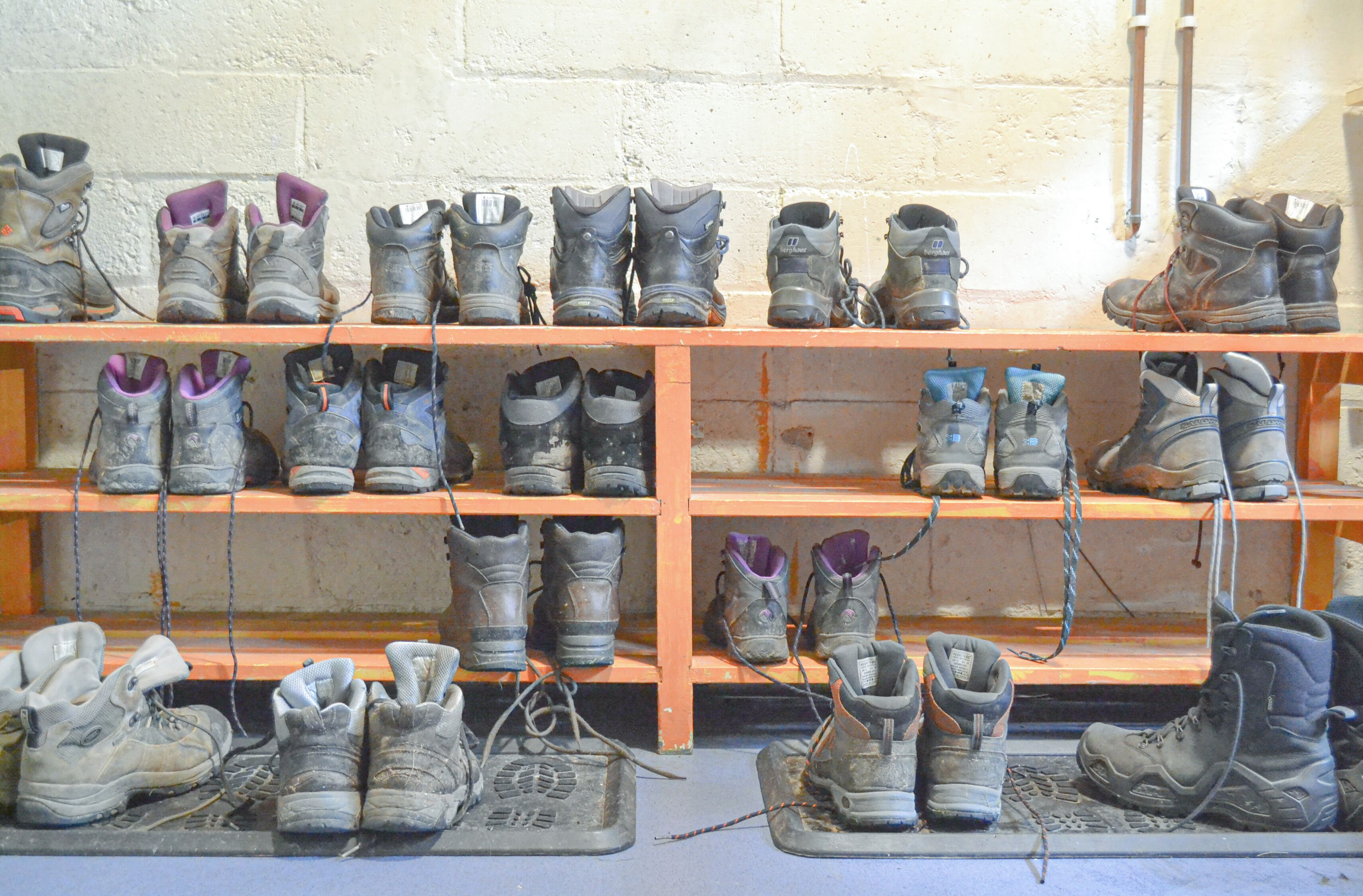 A row of shelves with various types of boots and shoes.