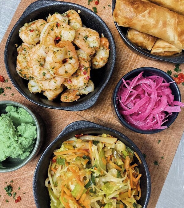 A variety of dishes including shrimp, pickled red onions, and a vegetable salad. - Borgsjö Strand (Erikslund)