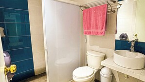 A modern bathroom with a shower, toilet, sink, and a mirror. - Hotel Montecarlo (San Luis Potosí)