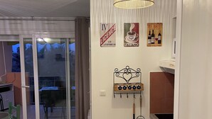 A kitchen with a washing machine, a hanging rack, and a ceiling light fixture. - Apartment lake salonique (Le Grau-du-Roi)