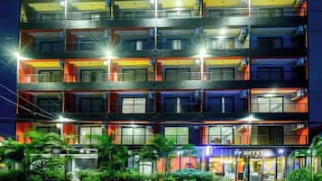 A multi-story hotel with balconies, a visible entrance, and a well-lit facade.