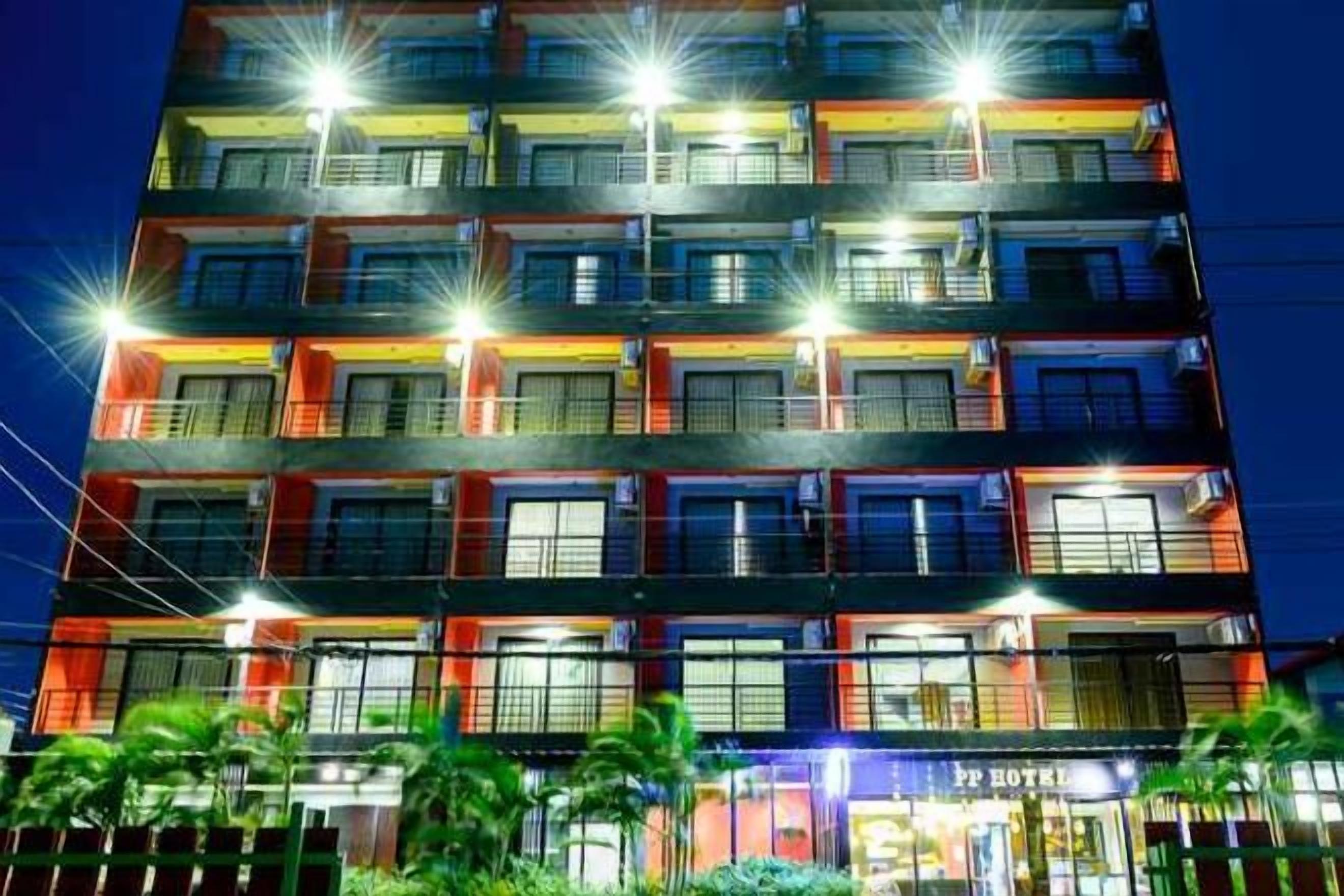 A multi-story hotel with illuminated balconies and a visible entrance labeled 'PPT HOTEL'.
