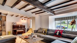 A modern living room with a piano, sofa, and coffee table. - Aysgarth Nook by Luxury Travel Emporium (Aysgarth)