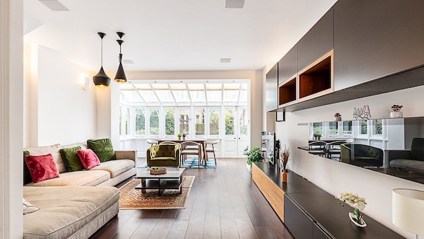 Un salon moderne avec un canapé, une table basse et un coin repas.