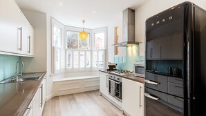 Une cuisine moderne équipée d’une cuisinière, d’un four et d’un réfrigérateur noirs intégrés.