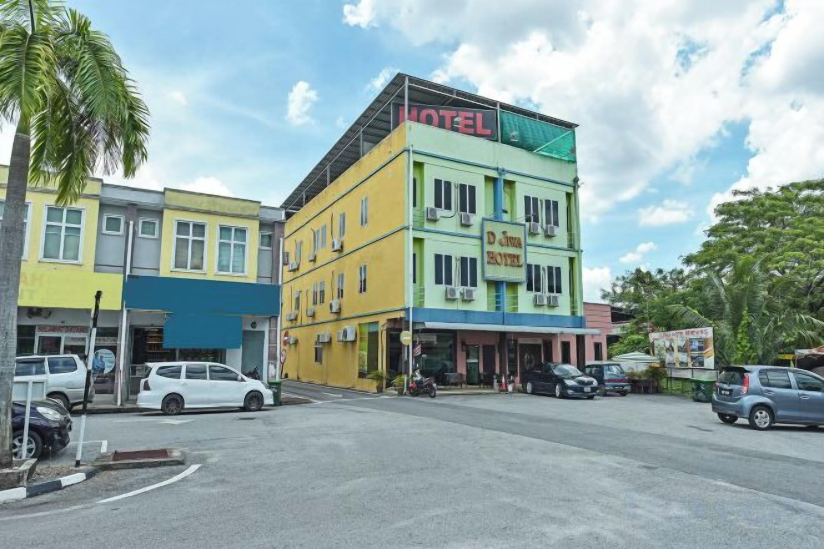 A hotel with a prominent 'HOTEL' sign, a visible entrance, and a parking area.