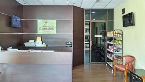 A reception area with a wooden reception desk, a sign for DJWA HOTEL, and a shoe rack with various items. - Hotel O Pendang Lake Formerly D Jiwa (Pendang)