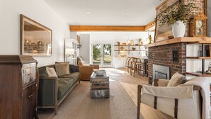 A spacious living room with a fireplace, a sofa, a coffee table, and a dining area. - Completely renovated heritage home in the Ozarks Mountain region of SW Missouri. (Billings)