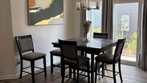 A dining area with a dark wood table, four chairs, a chandelier, and a large abstract painting on the wall. - 3/2 Villa in most desired Richmond neighborhood in the Villages. Jan-Apr rental (The Villages)