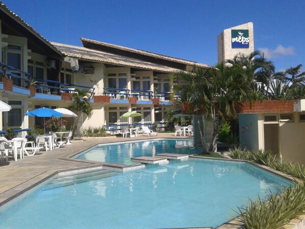 A hotel with a swimming pool, outdoor seating, and a sign for MEPs. - Rede Andrade Aracaju (Aracaju)