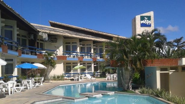 A hotel with a swimming pool, outdoor seating, and a sign for MEPs. - Rede Andrade Aracaju (Aracaju)