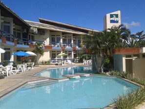 A hotel with a swimming pool, outdoor seating, and a sign for MEPs. - Rede Andrade Aracaju (Aracaju)