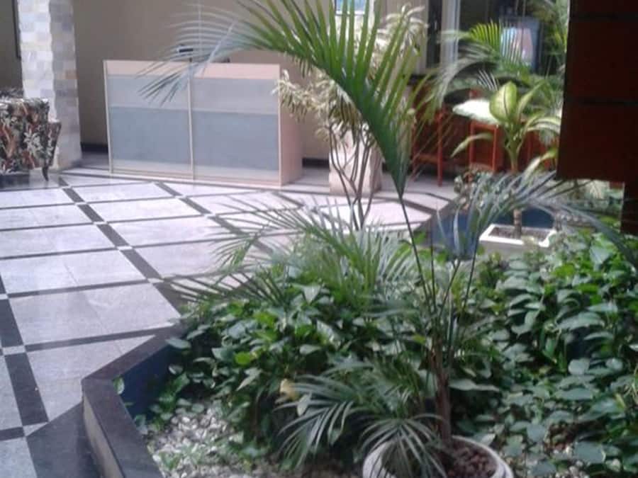 A courtyard with a tiled floor, potted plants, and a seating area.