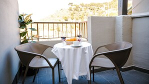 A balcony with a table set for two, featuring a white tablecloth, two chairs, a basket of fruit, and wine glasses. - Hotel Cullera Coast by Mij (Cullera)