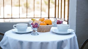 A table with two white cups and a basket of fruit on a balcony. - Hotel Cullera Coast by Mij (Cullera)