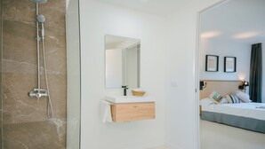 A modern bathroom with a shower, a mirror, and a wooden vanity. - Hotel Cullera Coast by Mij (Cullera)