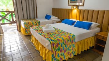 Habitación de hotel con dos camas, cabecera de madera, mesita de noche pequeña y ventana con cortinas.