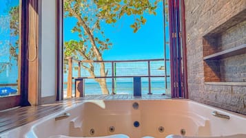 A hot tub with a view of the sea and trees.