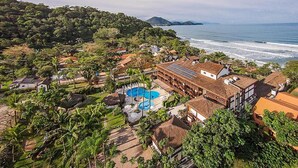 A resort with a pool, beach view, and tropical surroundings.