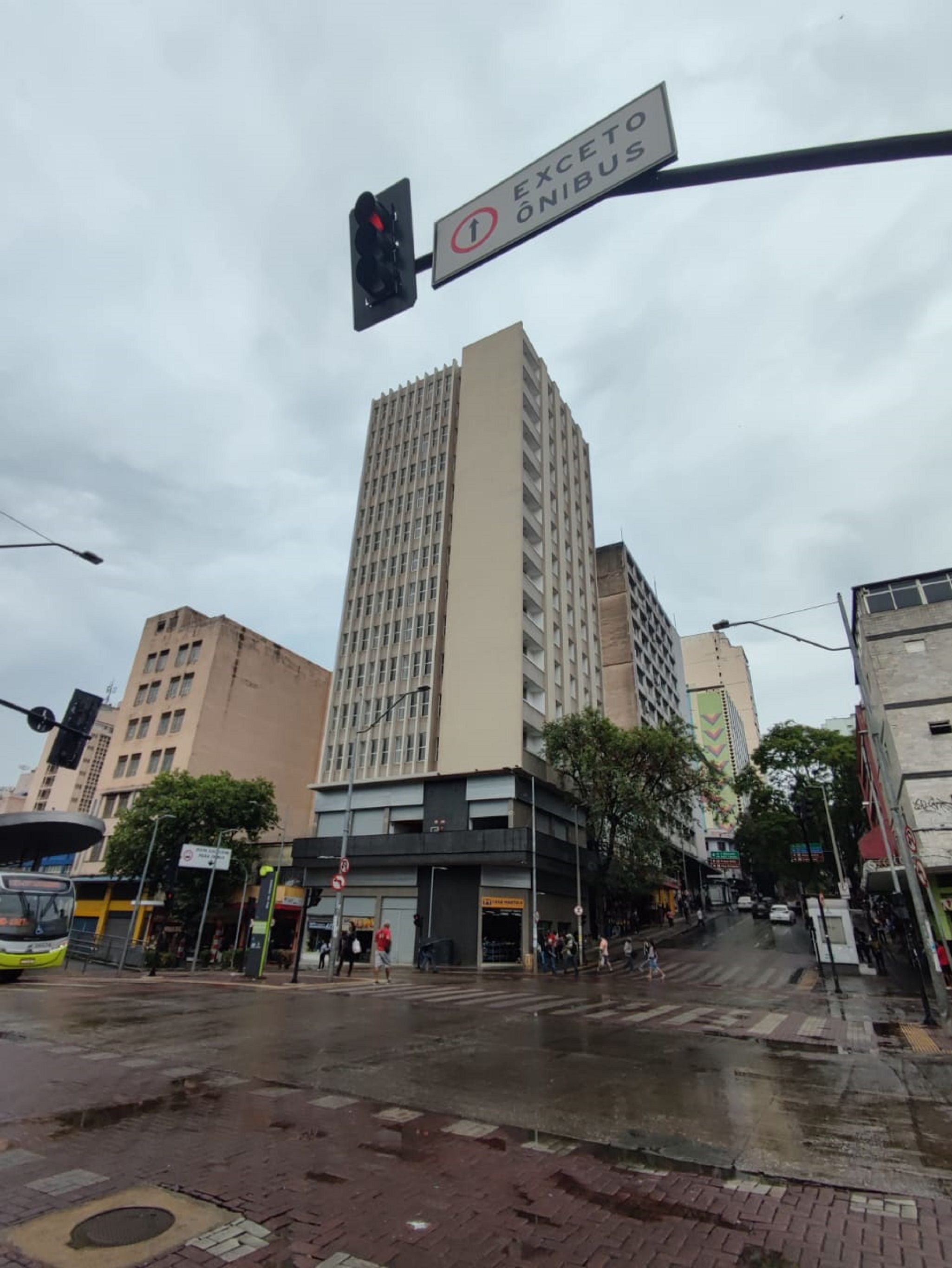 A tall building with a modern design, a pedestrian crossing, and a traffic light.