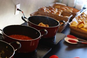 A kitchen counter with two red pots, a basket of bread rolls, and a plate with a red substance. - Samba Belo Horizonte Vintage Apart Hotel (Belo Horizonte)